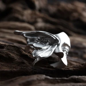 Close-up of the textured moth wing and eye-like mark on the Gaze silver ring, with the face behind