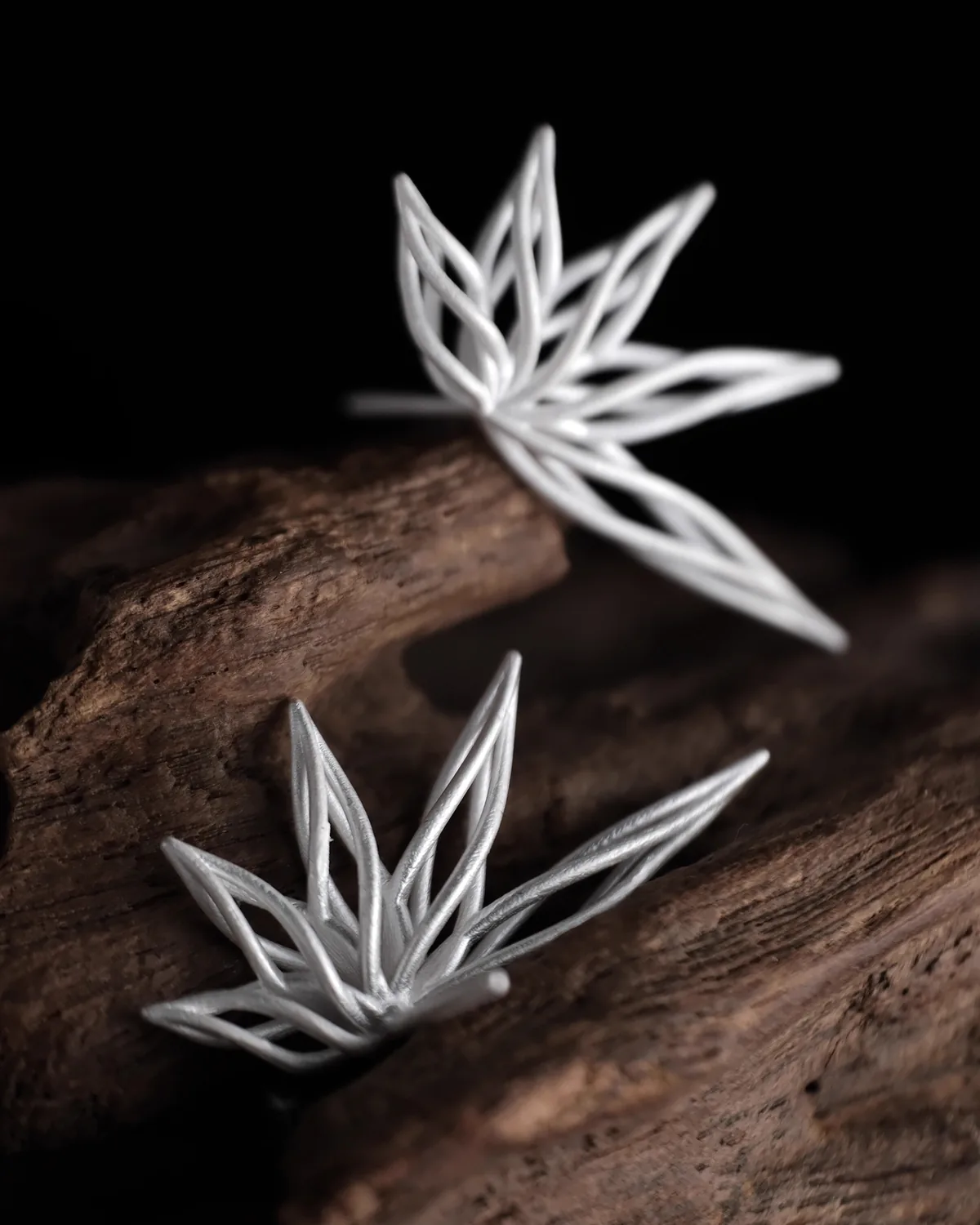 Dancing Petals Silver Earrings Sculptural silver Dancing Petals earrings on dark wood