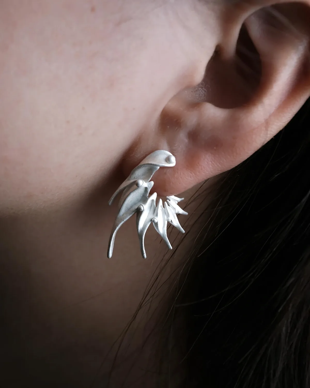 Ethereal Wings S925 Silver Earring Worn Ethereal Wings S925 silver earring with layered pointed forms worn beside dark hair