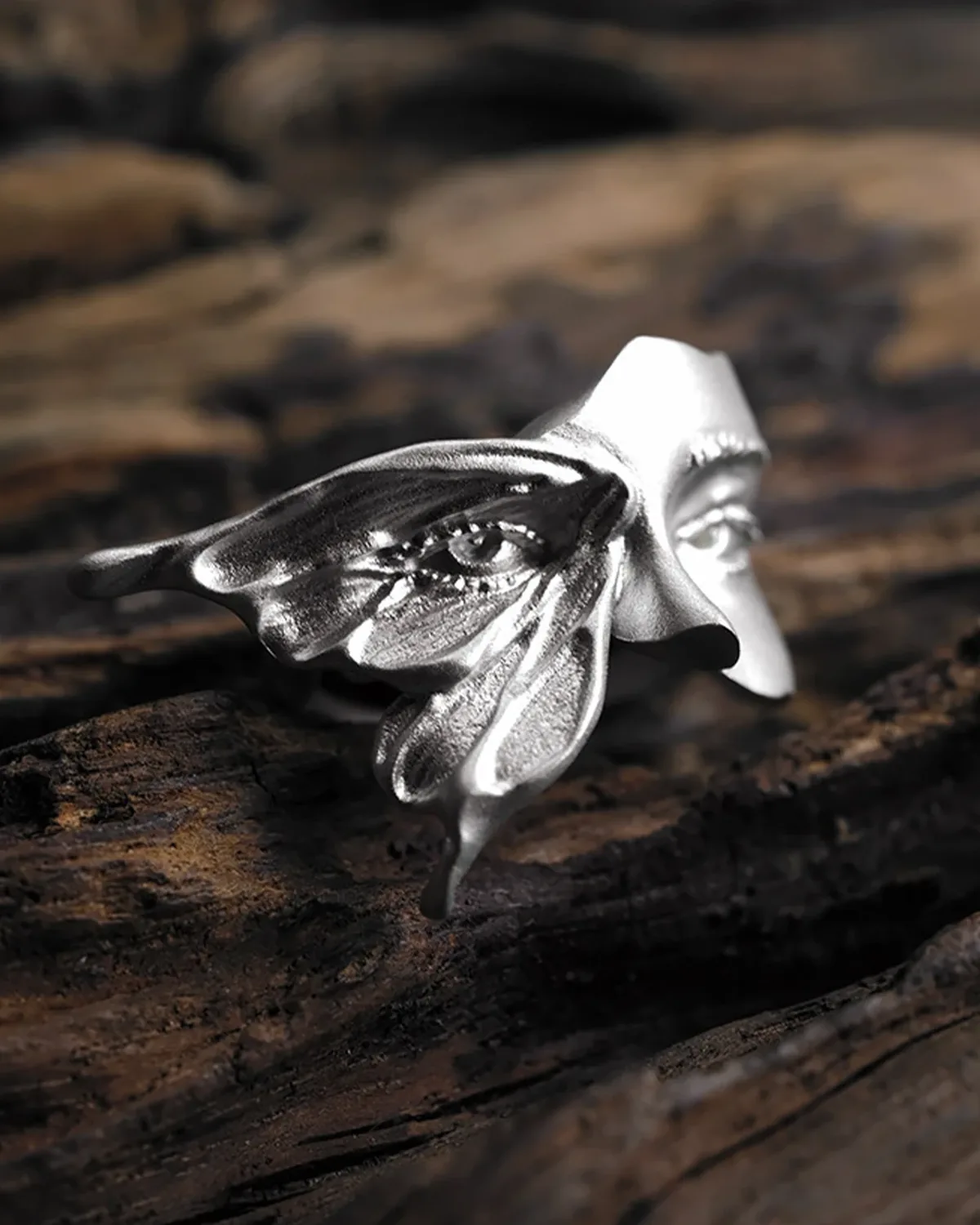 Gaze Sterling Silver Moth Ring Gaze silver ring with an eye-marked moth wing and a partial sculpted face on weathered wood