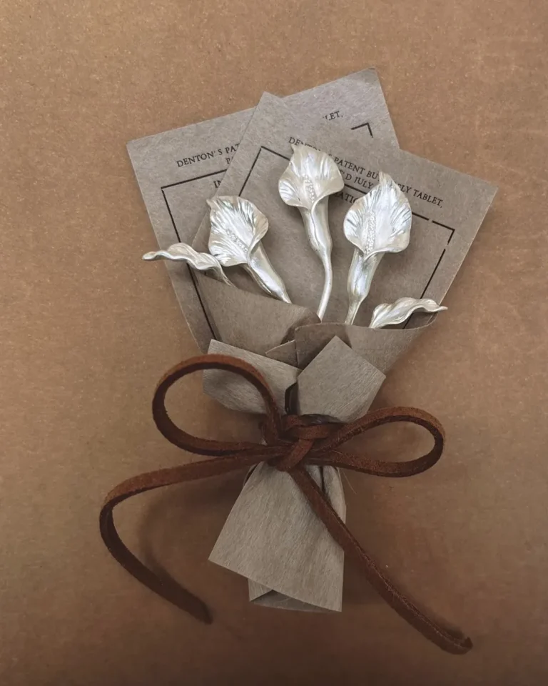 Blogs 1 Three sculpted silver calla lilies tied into a miniature bouquet on a warm paper background