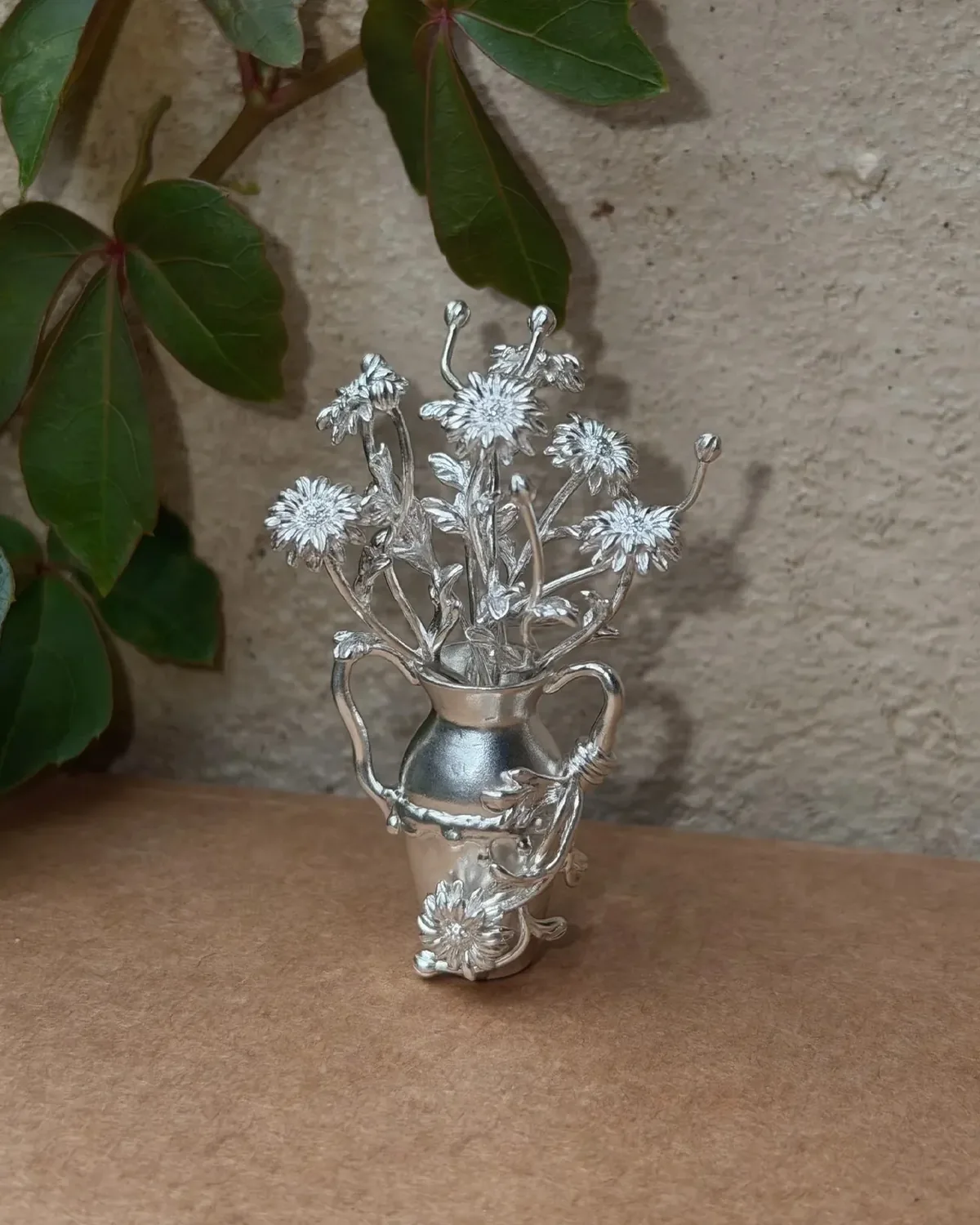 The Smallest Garden Silver Vase The Smallest Garden miniature silver vase filled with silver flowers on a table
