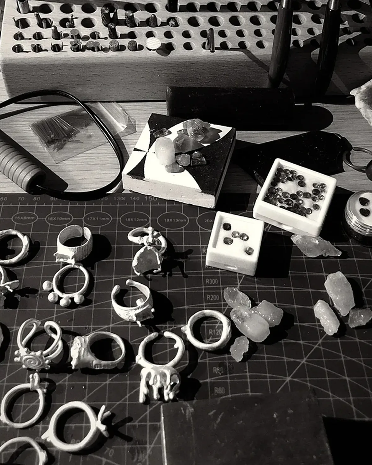 Jewelry Studio Workbench Jewelry studio workbench with ring forms, stones, and hand tools in monochrome