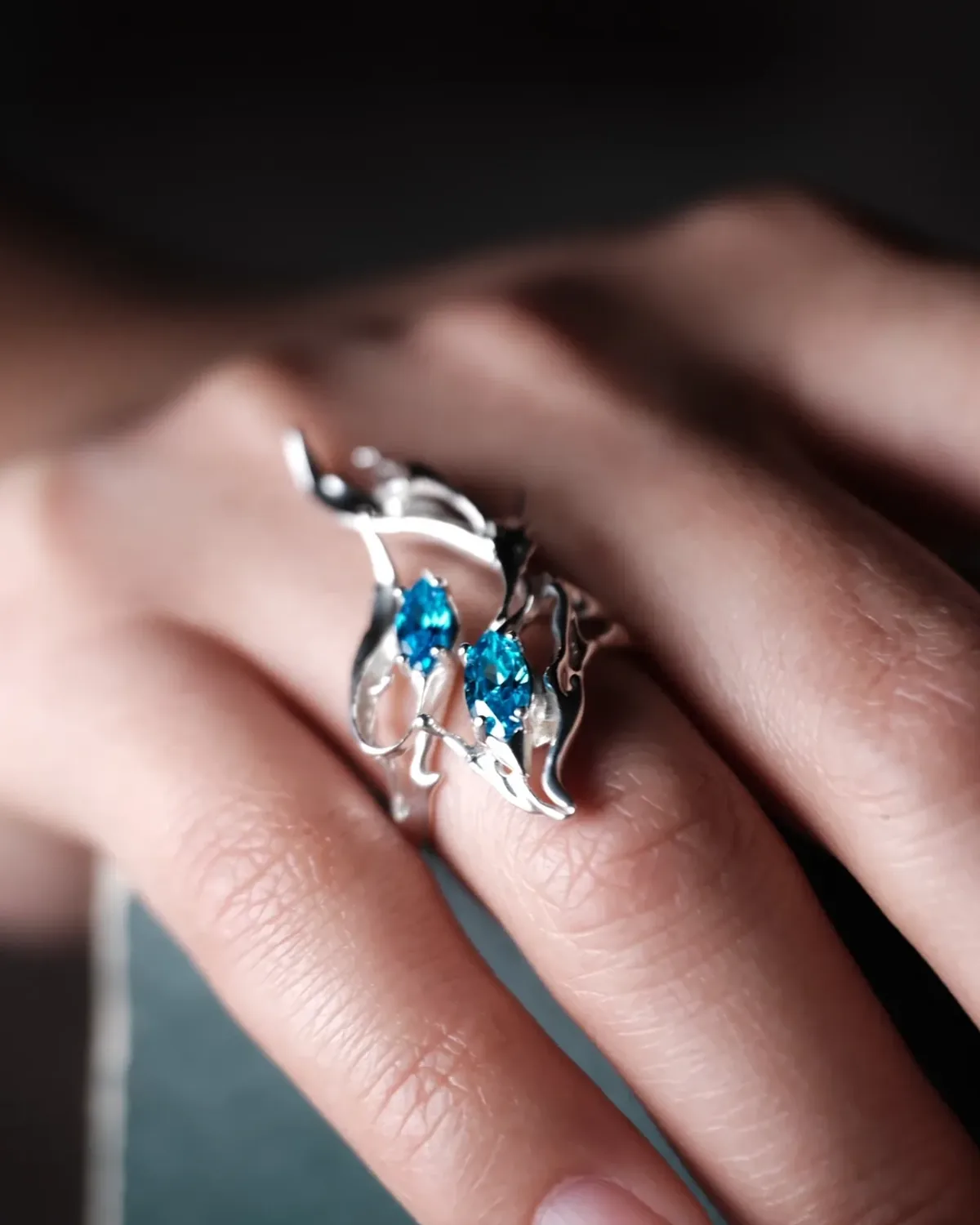 Tidewake Fishtail Silver Ring Tidewake sculptural silver fishtail ring with blue stones worn on a hand
