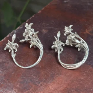 Back view of two little lily rings, with a single band on the left and an openwork band on the right